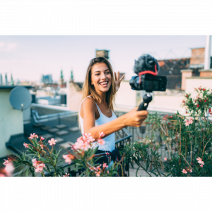 Woman in a rooftop garden videoing herself and being confident on video