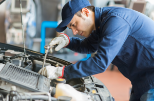 Photo of a car mechanic working on a car engine to give an example of a behind the scenes video